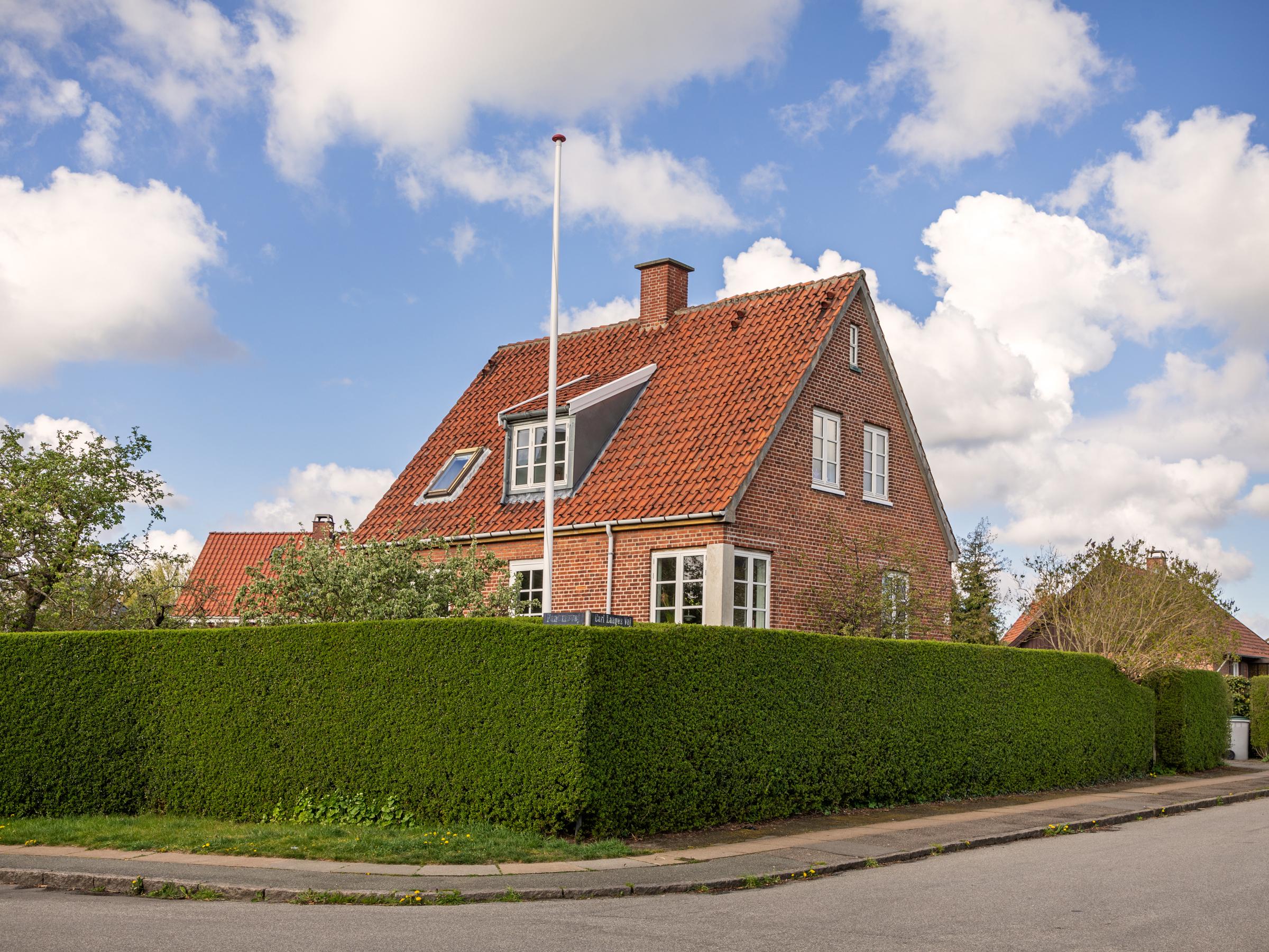 Red brick house with green hedge